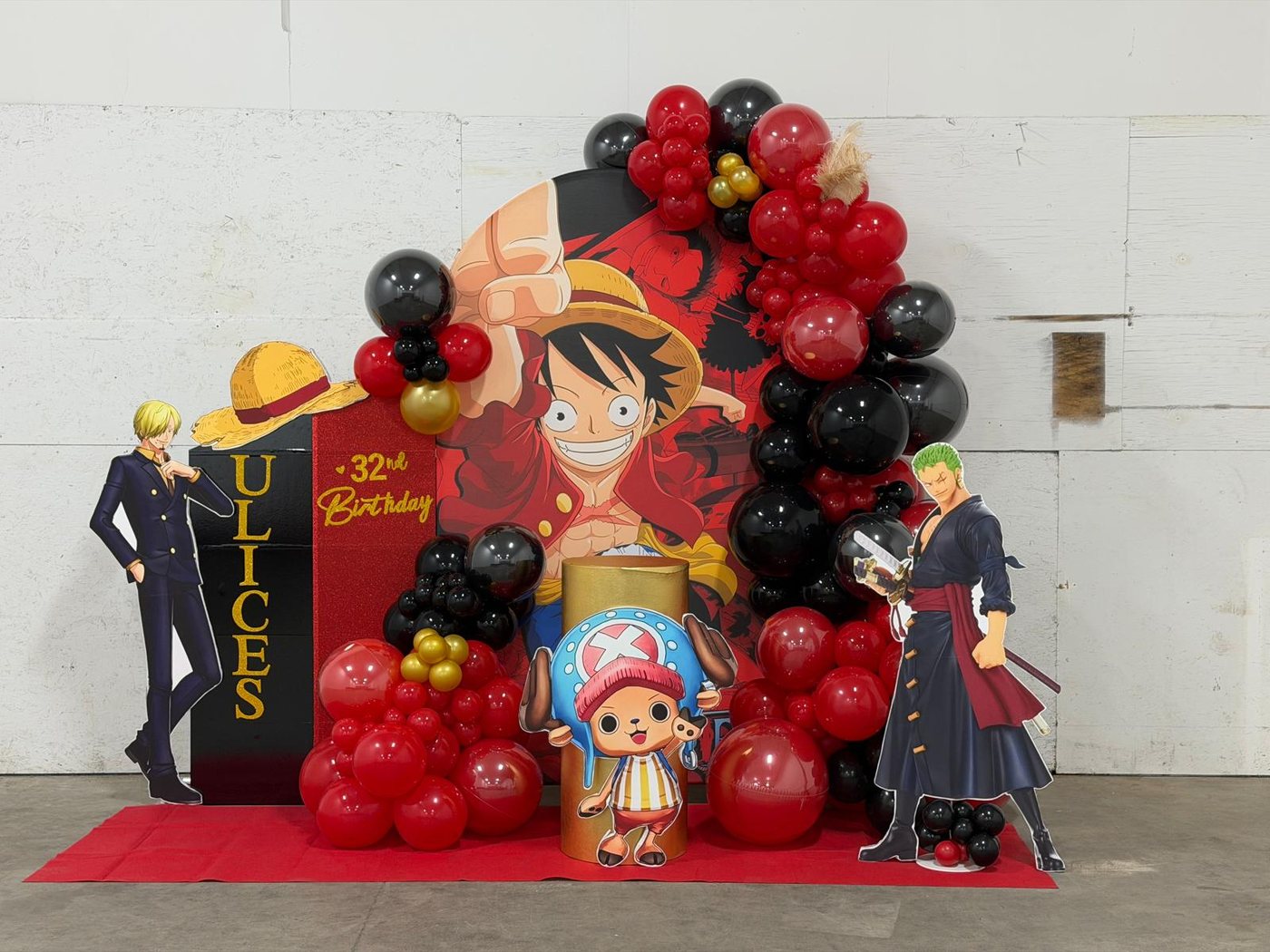 Red and black anime themed birthday backdrop with balloons, custom sign, and character standees
