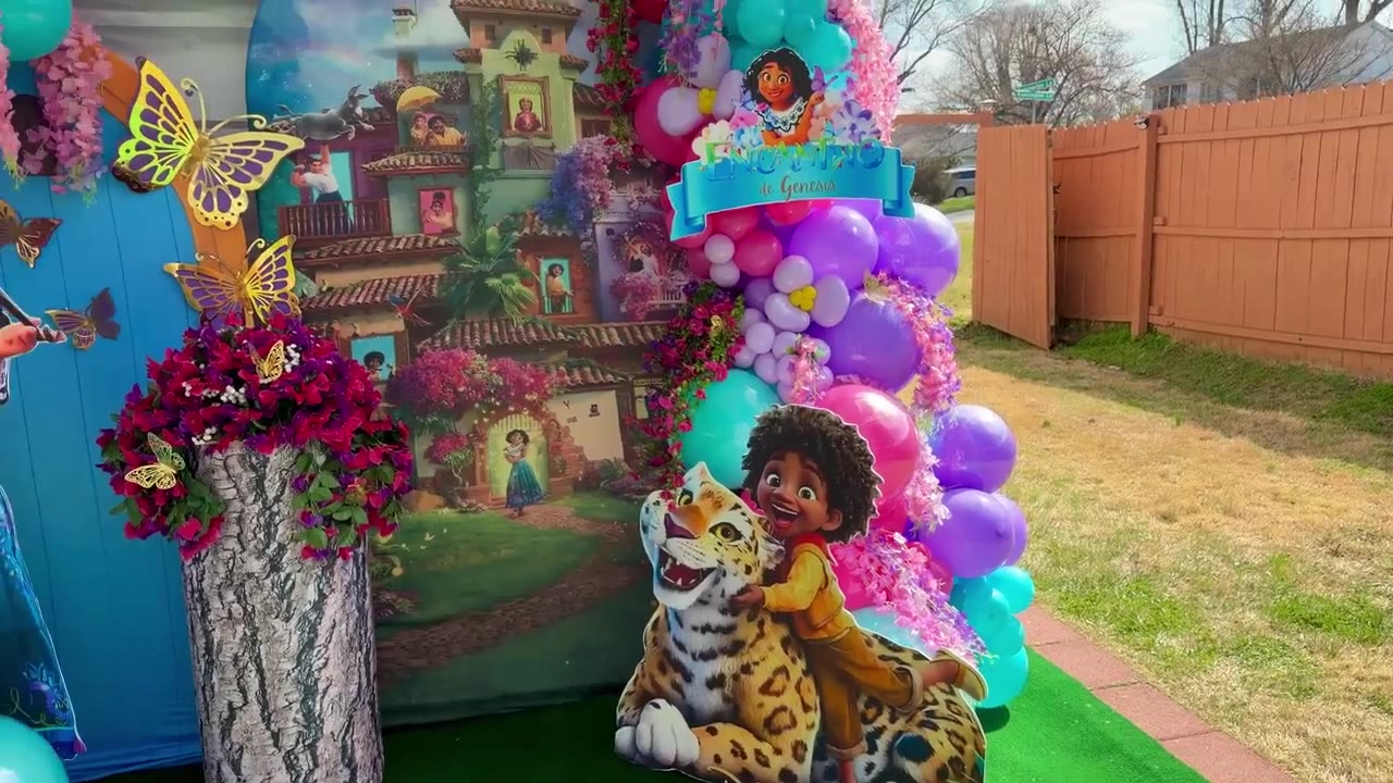 Encanto themed outdoor event backdrop with balloons and butterflies